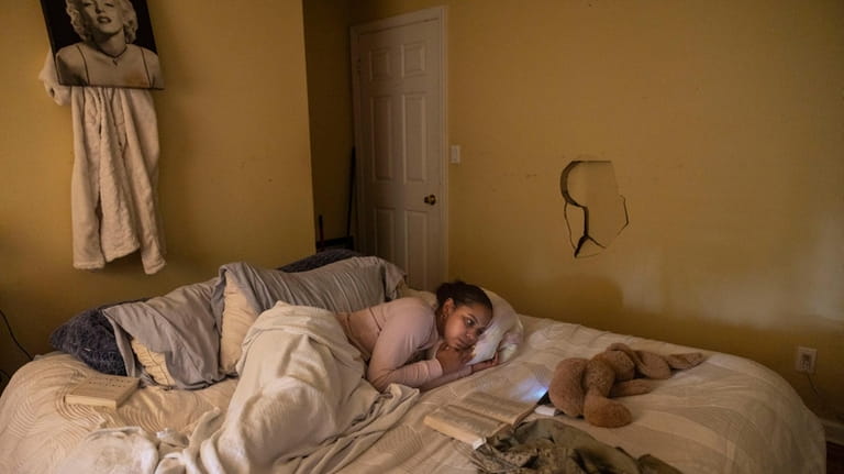 Tatyana Taylor watches TV on her phone in a bedroom she...